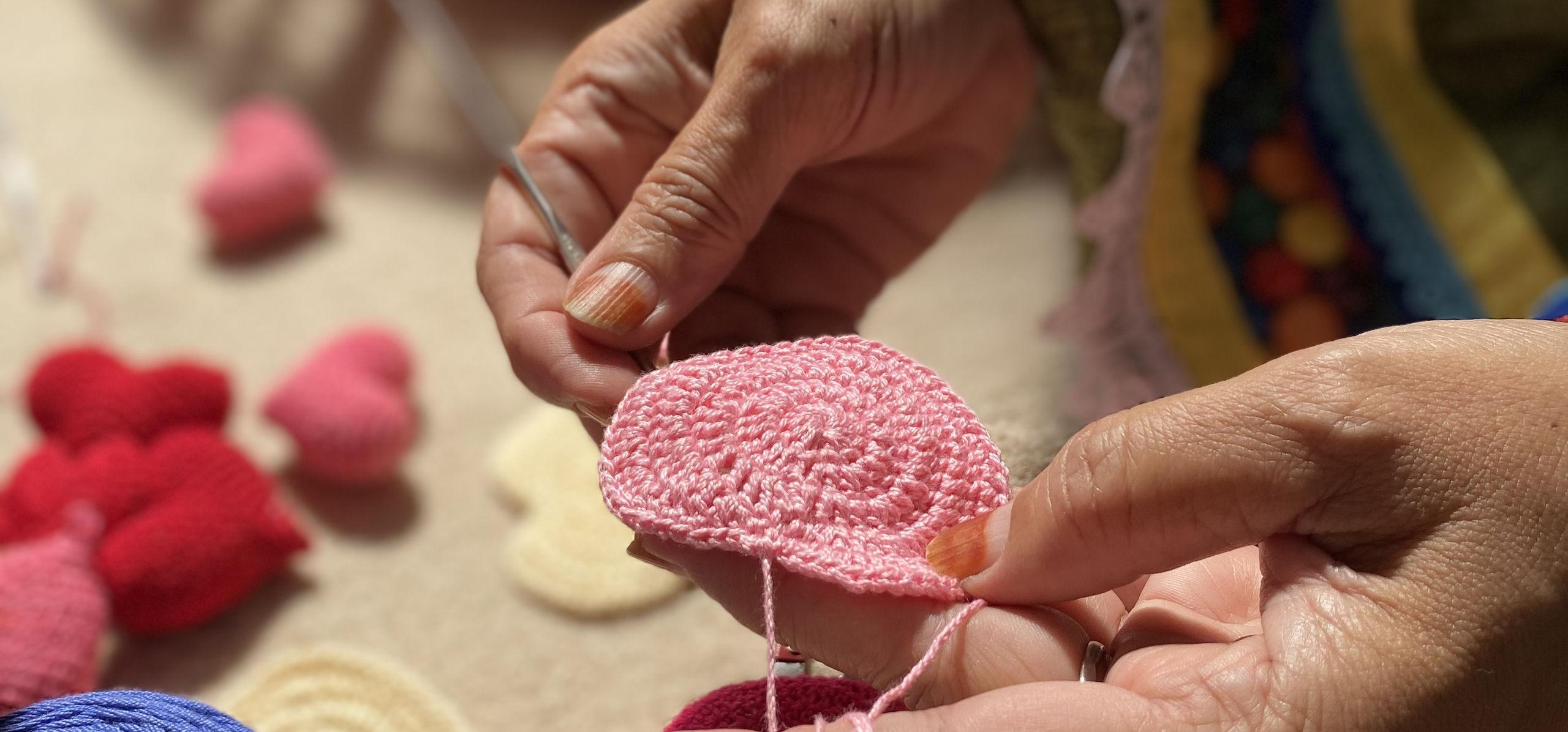 An artisan crocheting a heart by hand
